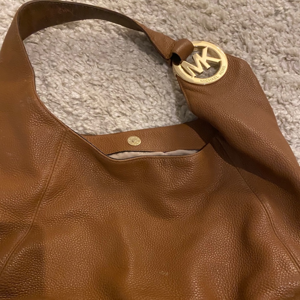 Hobo style Brown leather purse with gold lettering.